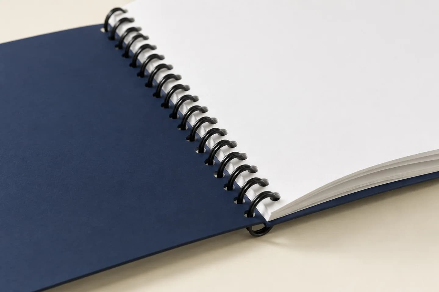 Close-up of black twin-loop binding through an open navy-cover workbook
